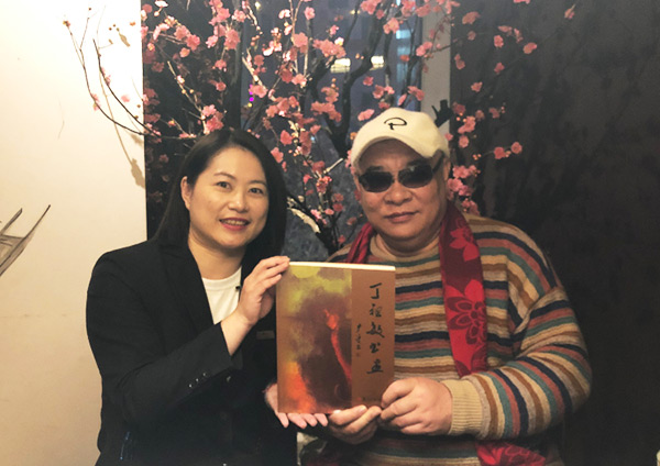 丁祖敏（右）向台湾同胞赠送新出版的《丁祖敏书画》